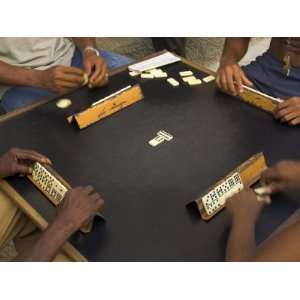  The Hands of a Group of Four People Playing Dominos in the 
